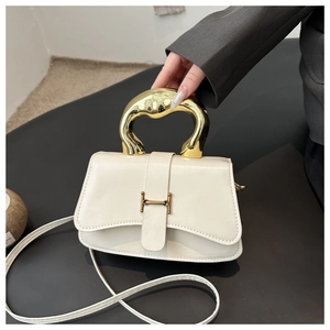 Detail der cremefarbenen Ledertasche mit goldenem Metallgriff und H-Verschluss