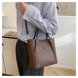 Detail of dark brown pebble leather tote bag with adjustable strap and metal buckle