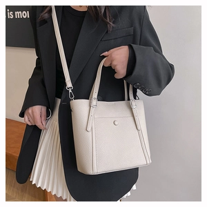 Detail of beige litchi grain tote bag with front pocket and adjustable shoulder strap