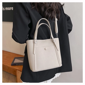 Minimalist beige pebble leather tote bag with front pocket and adjustable shoulder strap
