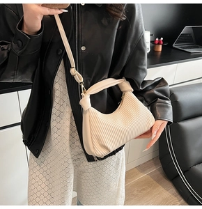 Détail du sac croissant plissé beige avec anse nouée et bandoulière réglable