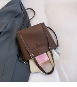 Detail of spacious dark brown leather tote interior with daily essentials and grained texture
