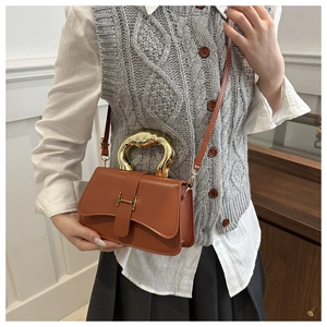 Detailansicht der braunen Ledertasche mit goldenem Wellengriff und H-Schnallen-Detail
