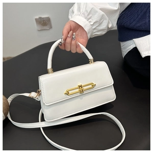Close-up of white PU leather crossbody bag with golden metal twist lock and handle