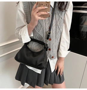 Détail du petit sac carré noir plissé avec poignée nouée et bandoulière réglable
