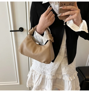 Détail d'un sac hobo plissé kaki avec poignée nouée élégante et texture en cuir synthétique