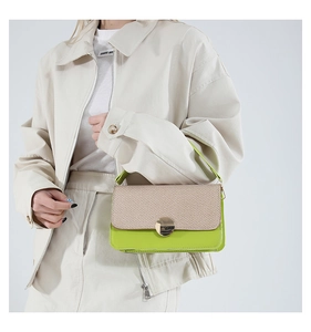Detail of color-block green leather handbag with beige woven texture and gold clasp