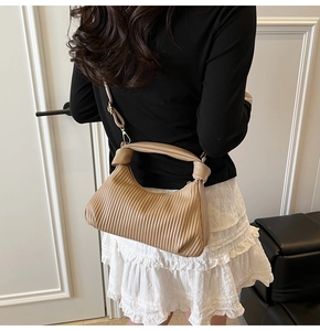 Détail du sac plissé kaki avec poignée nouée et bandoulière réglable amovible