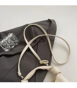 Détail de la bandoulière réglable en cuir PU crème avec crochet métallique doré élégant