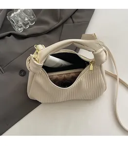 Détail du sac plissé beige montrant l'espace pour portefeuille et cosmétiques