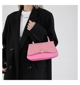 Detail of pink leather and twill fabric texture on a square bag with gold metal buckle