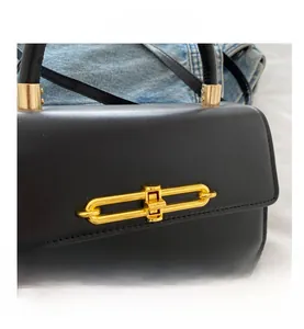 Close-up of a black leather handbag featuring a unique gold chain link metal lock