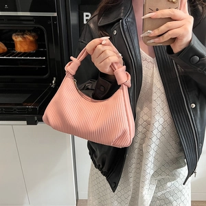 Sac à main rose plissé avec poignée nouée élégante dans un cadre moderne