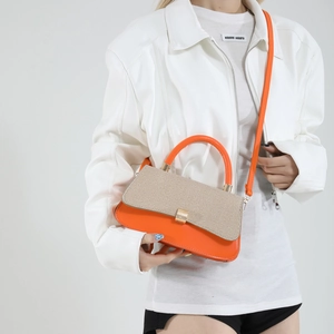 Fashionable orange and beige woven handbag with gold lock and sleek leather strap