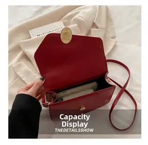 Capacity display of red pebble leather crossbody bag showing interior space for a long wallet