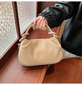 Detail of knot handle and embossed logo on beige pleated leather shoulder bag