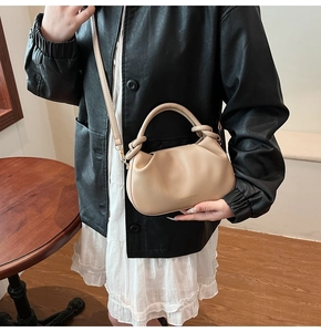 Detail of beige pleated cloud bag with soft PU leather texture and cylinder handle