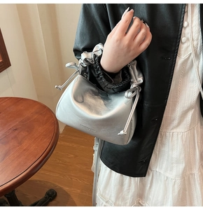 Detailed close-up of metallic silver drawstring handbag with Fashion & Bags print