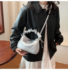 Detail of silver pleated handle and metallic faux leather on stylish crossbody bag