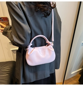 Detail view of a lavender pleated cloud bag showing the textured synthetic leather and strap