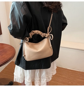 Detail of beige pleated shoulder bag with knotted bow and Fashion & Bags text logo