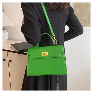 Detail of lime green pebble leather Kelly style handbag with gold twist lock and handle