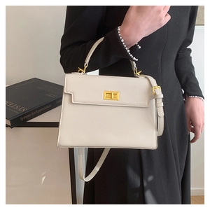 Detail of white Saffiano leather handbag with gold metal twist lock and sleek handle