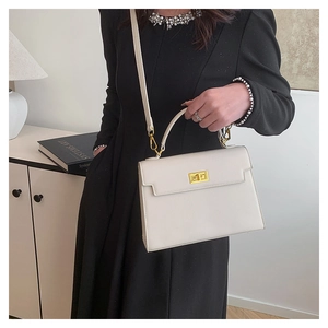 Detail of white lychee leather Kelly style handbag with polished gold rotary clasp