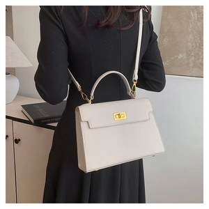 Side view of a white trapezoid Kelly bag with cross pattern texture and gold buckle