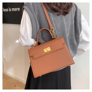 Brown lychee leather handbag featuring a gold twist lock and adjustable crossbody strap