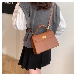 Detailed back view showing the brown vintage leather Kelly style bag worn by model