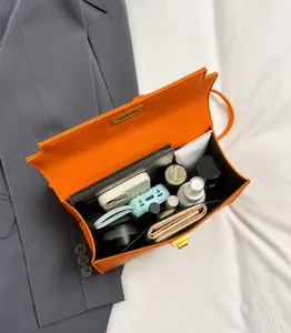 Top view of open orange textured leather handbag showing spacious interior for essentials