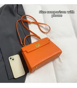 Orange lychee leather handbag detail with gold hardware and phone for size reference