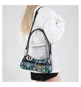 Detailed macro view of colorful snakeskin texture and black strap on faux leather bag