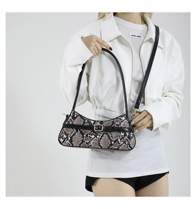 Detailed close-up of snakeskin embossed pattern with black strap and gold buckle