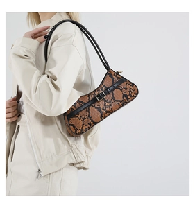 Close-up of snake skin texture and buckle detail on the minimalist underarm baguette bag