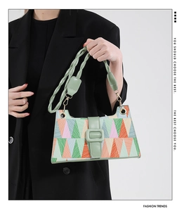 Detail of geometric patchwork handbag with colorful triangles and olive green leather trim