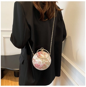 Detailed view of spherical floral lace evening bag with gold chain and ring handle