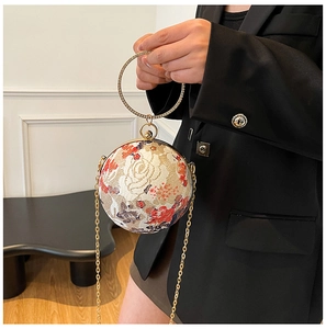 Detailed view of spherical floral evening bag with lace embroidery and rhinestone handle