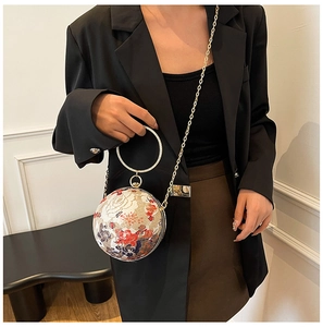 Detail of spherical evening bag with floral embroidery and rhinestone ring handle