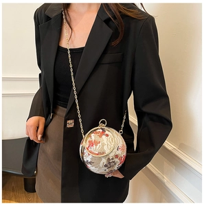 Detailed view of spherical floral embroidery evening bag with golden chain and round handle