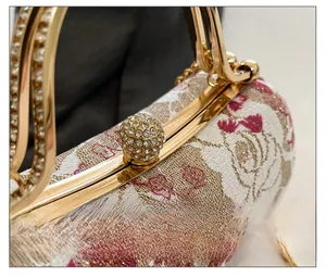 Close-up of vintage evening box bag with floral pattern and sparkling diamond clasp