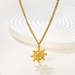 Golden helm pendant necklace with curb chain displayed on a white textured background