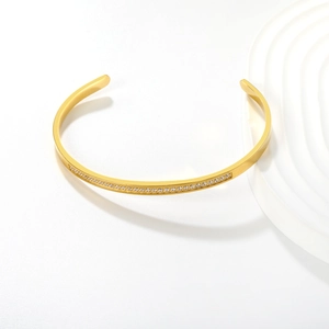Elegant 18K gold-plated stainless steel cuff bangle with micro-pave crystals on white backdrop