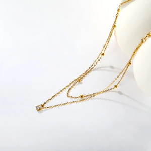 Elegante collana a due strati in oro 18K con perline delicate e ciondolo a diamante quadrato