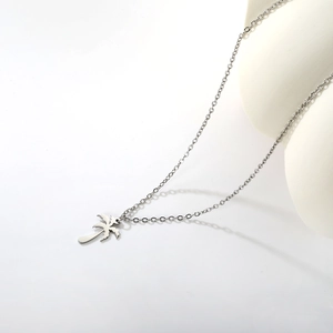 Vue détaillée d'un collier pendentif palmier argenté minimaliste au fini lisse