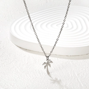 Détail du pendentif palmier argenté sur une chaîne fine au style estival et tropical