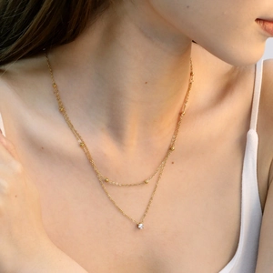 Elegante collana a doppio strato placcata oro 18K con zircone tondo su modella donna