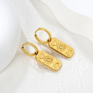 Golden rectangular drop earrings with celestial sun and moon engraving on white background