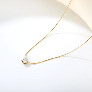 Detail of a gold star pendant necklace with sparkling clear cubic zirconia stones